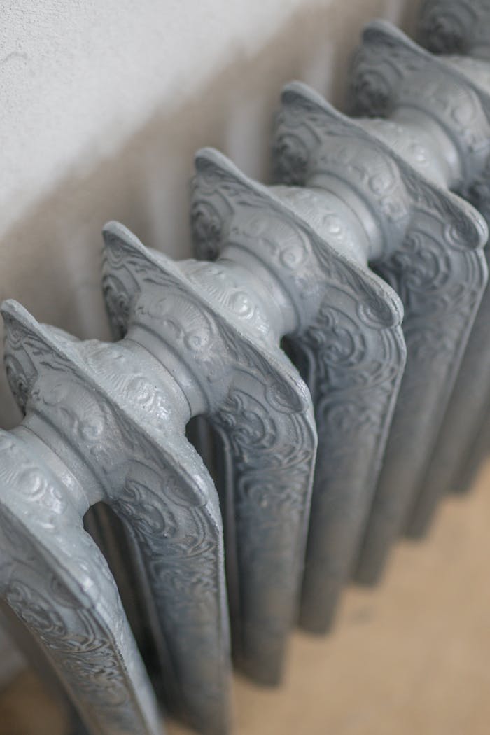 A detailed close-up of an ornate vintage cast iron radiator indoors.